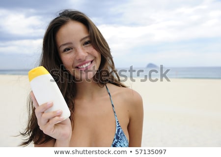 Woman Showing Suncream At The Beach Imagine de stoc © mangostock