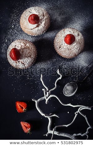 Foto stock: Christmas Cupcakes With Strawberries And Powdered Sugar On Black Background Top View