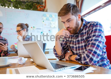 Foto d'archivio: Serious Bearded Young Man Using Laptop