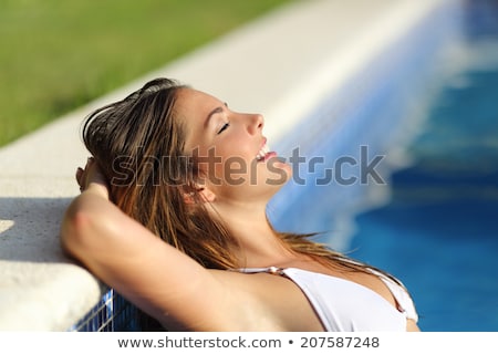 商業照片: Beautiful Woman In Green Bikini Relaxing By Pool Side