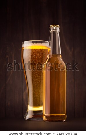 Сток-фото: Transparent Beer Bottle And Glass Weizen With Golden Lager On Dark Brown Wood Board Vertical Mock