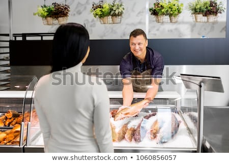 Stock fotó: Male Seller Showing Seafood At Fish Shop Fridge