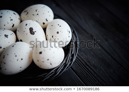 Foto d'archivio: Whole Chicken Eggs In A Nest On A Black Rustic Wooden Background Easter Symbols