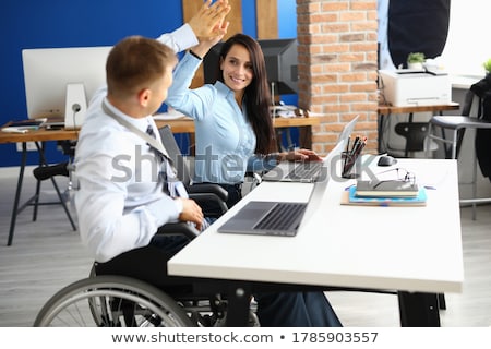 Stock photo: Businesswoman Helping Disabled Colleague In Wheelchair