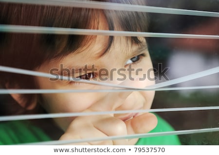 [[stock_photo]]: Portrait Of An Innocent Small Boy Peeping Through Window With Jalousie