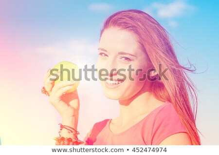 Foto stock: Happy Woman With Apple Smiling Enjoying Good Weather Sunny Day By The Sea