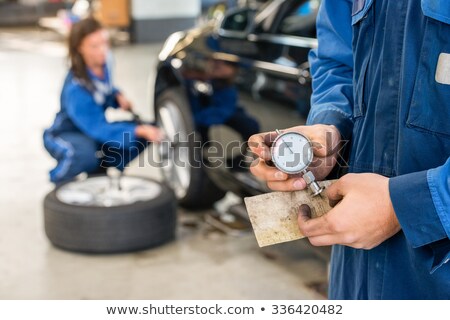 Stok fotoğraf: Midsection Of Mechanic Holding Analog Gauge In Garage