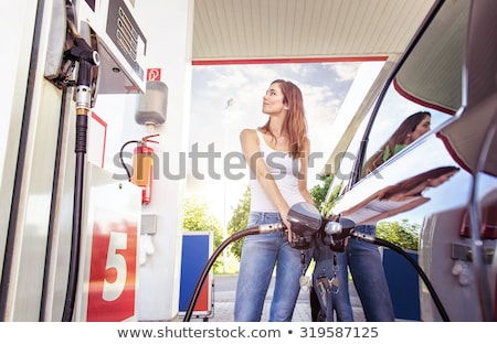 Stok fotoğraf: Woman Fills Petrol Into The Car At A Gas Station