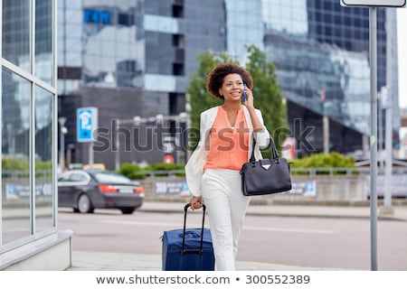 Stok fotoğraf: African Woman With Bag Talking On Smartphone