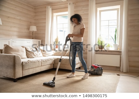 Stok fotoğraf: African Woman Using Vacuum Cleaner