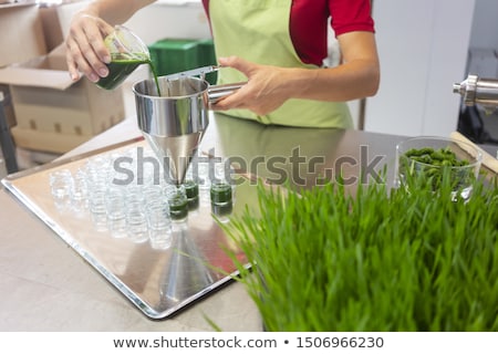 Сток-фото: Woman Filling Wheatgrass Smoothie In Glasses