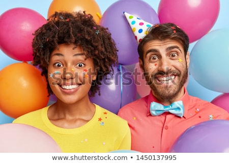 ストックフォト: Happy Couple In Party Hats With Balloons