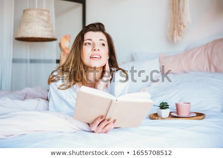 ストックフォト: Smiling Woman In Underwear Reading A Book