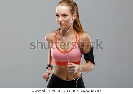 Сток-фото: Portrait Of A Serious Woman Athlete Running With Earphones