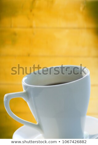 Stockfoto: White Cup With Saucer Against Blurry Wood Panel