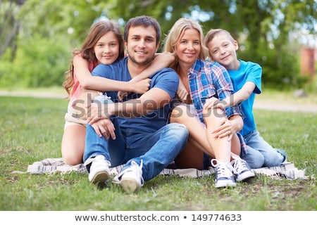 Yaz aylarında açık dört kişilik aile çimenlerin üzerinde oturuyor Stok fotoğraf © Pressmaster