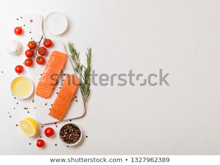 Fresh Raw Salmon Slice On Chopping Board With Oil Tomatoes And Lemon On Stone Kitchen Table Backgrou Foto stock © DenisMArt