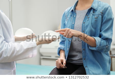 Foto stock: Woman Holding Silicon Breast Implant In Hand