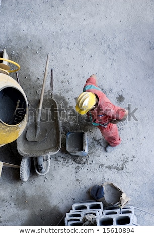 Stockfoto: Male Construction Worker Mixing In Heavy Machinery