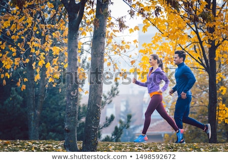 Woman And Man Jogging Or Running In Park During Autumn Foto stock © Kzenon