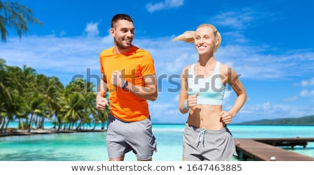 Stock fotó: Happy Couple With Fitness Trackers On Summer Beach