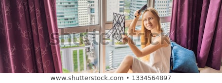 Foto stock: Woman Sits By The Window And Uses An Electronic Hairbrush Banner Long Format