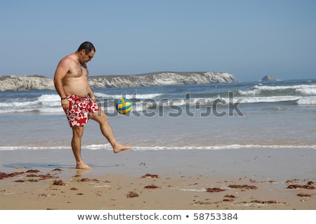 Stockfoto: Fat Man Playing With A Ball On The Beach