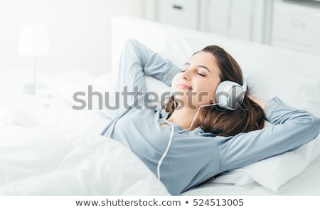 Сток-фото: The Young Girl In Bed Listening To Music Headphones