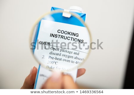 Stock foto: Human Holding Magnifying Glass Over Cooking Instructions