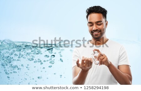 Stockfoto: Happy Indian Man With Perfume Over Blue Background