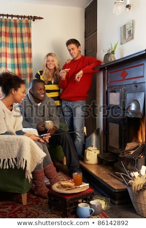 Foto stock: Young Adults Making Toast On Open Fire