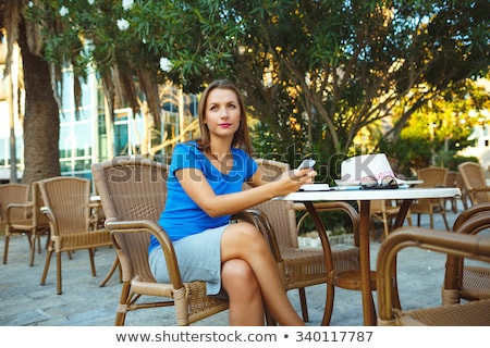 Foto stock: Young Pretty Modern Blogger Using Smartphone And Makes Notes In