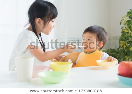 Foto stock: Feeding Baby Brother