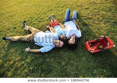 Stockfoto: Couple Laying Field With Picnic Basket