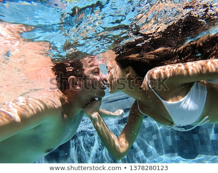 Сток-фото: Young Couple Swimming In Swimming Pool Underwater View