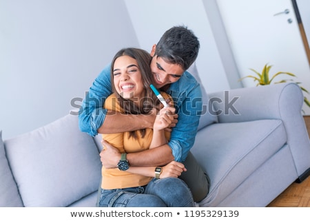 Stock fotó: Cheerful Couple Finding Out Results Of A Pregnancy Test Sitting On Bed