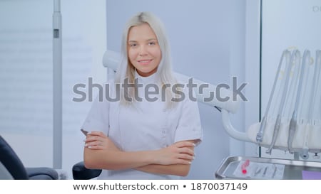 Stock photo: Dentist Young Female Standing In Her Office And Looking At Camera