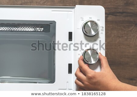 Сток-фото: Girl Adjusting Temperature Of Microwave Oven