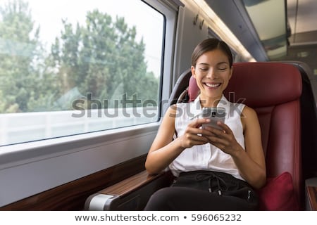 Smiling Asian Businesswoman Using Smartphone Social Media App While Commuting To Work In Train Woma Stockfoto © Maridav