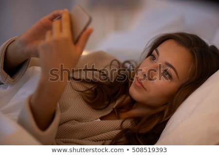 Foto stock: Woman Text Messaging In Bed