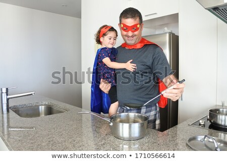 Сток-фото: Father And Daughter Pretending To Be Superhero In Kitchen