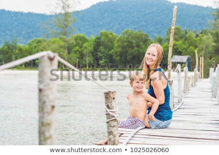 Zdjęcia stock: Mom And Son Are Sitting On The Old Pier And Enjoying The Sea