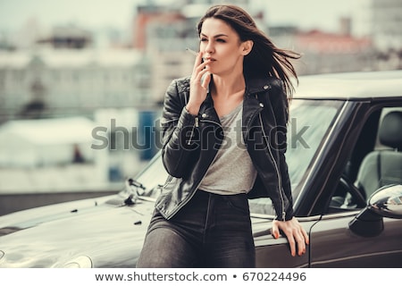 Stok fotoğraf: Young Woman Smoking While Driving Her Car