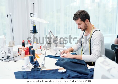 Young Man Concentrating On Sewing Clothing Item On Machine Foto stock © Pressmaster
