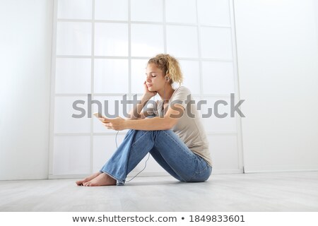 Zdjęcia stock: Smiling Ginger Woman In Shirt And Jeans Sitting On Floor