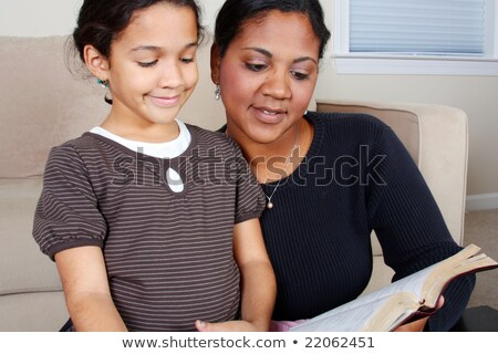 Foto stock: Minority Woman And Her Daughter Reading The Bible