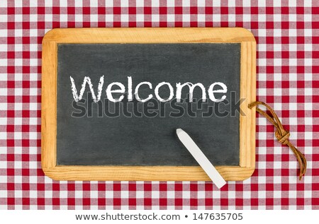 Stok fotoğraf: Blackboard With Text Welcome On A Checkered Tablecloth