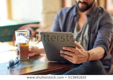 Foto stock: Close Up Of Man With Tablet Pc And Beer At Pub