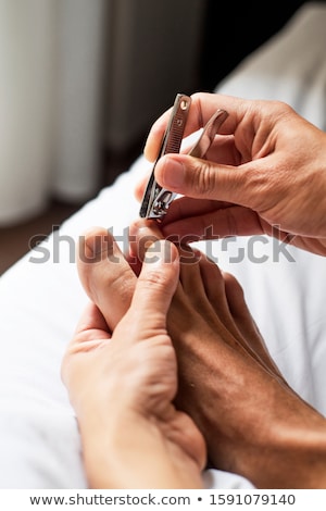 Stock fotó: Young Caucasian Man Cutting His Toenails