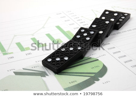 Stockfoto: Risky Domino Over A Financial Business Chart